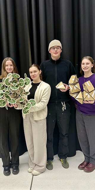 Vier Studierende halten selbstgebauten Modelle 